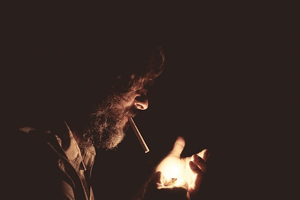 タバコに火をつける男性