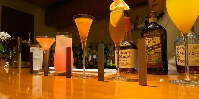 バーカウンターに並ぶカクテルと電子タバコ